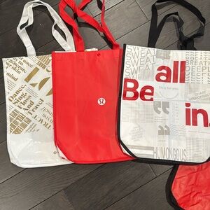 Three large Lululemon shopping tote bags